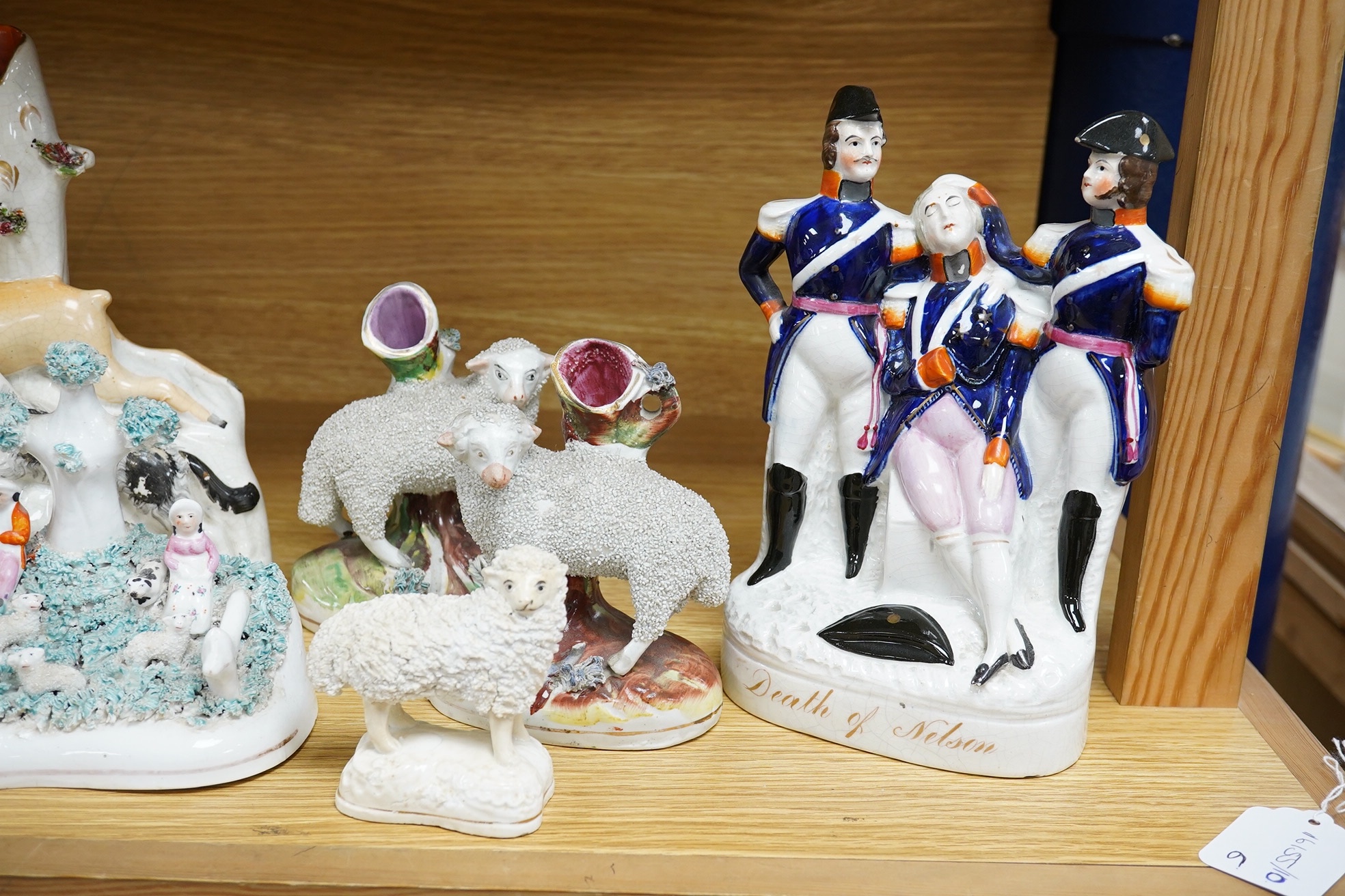 Six Victorian Staffordshire models including Death of Nelson, 21.5cm high, a deer and hound group, and various sheep. Condition - fair to good